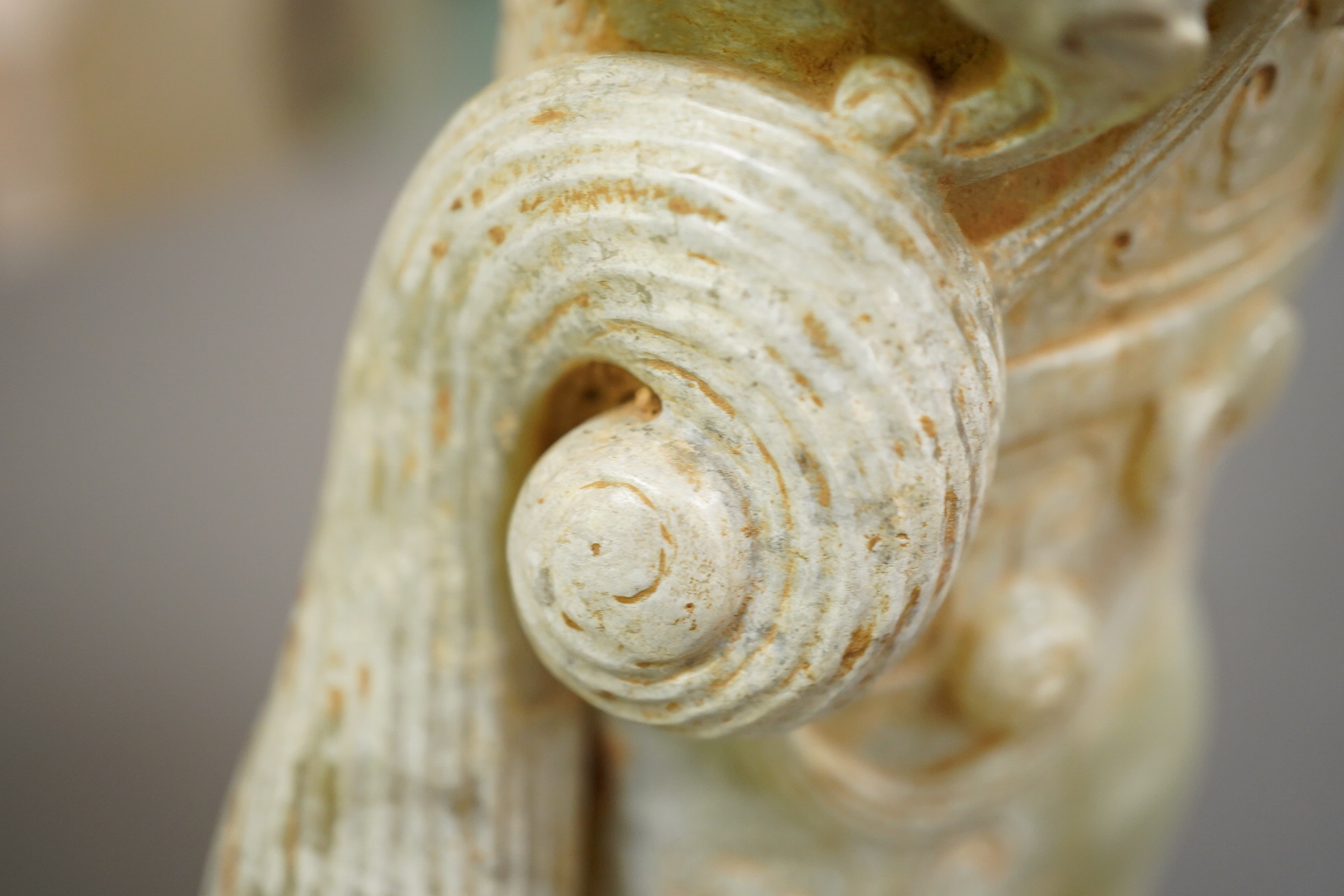 A large Chinese archaistic pale celadon and calcified jade rhyton, on a hardwood stand, 17.5cm high. Condition - fair to good.